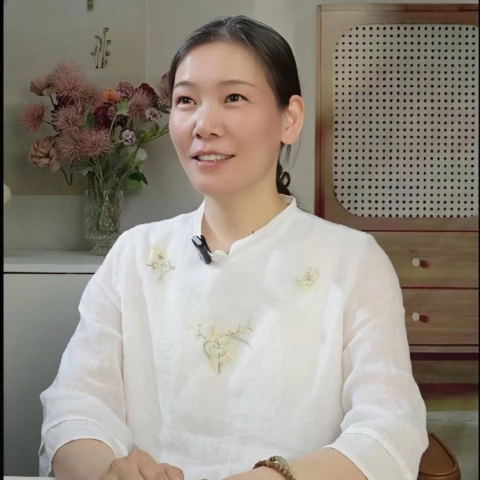 胡一萍老师身着白色中式上衣的半身照片